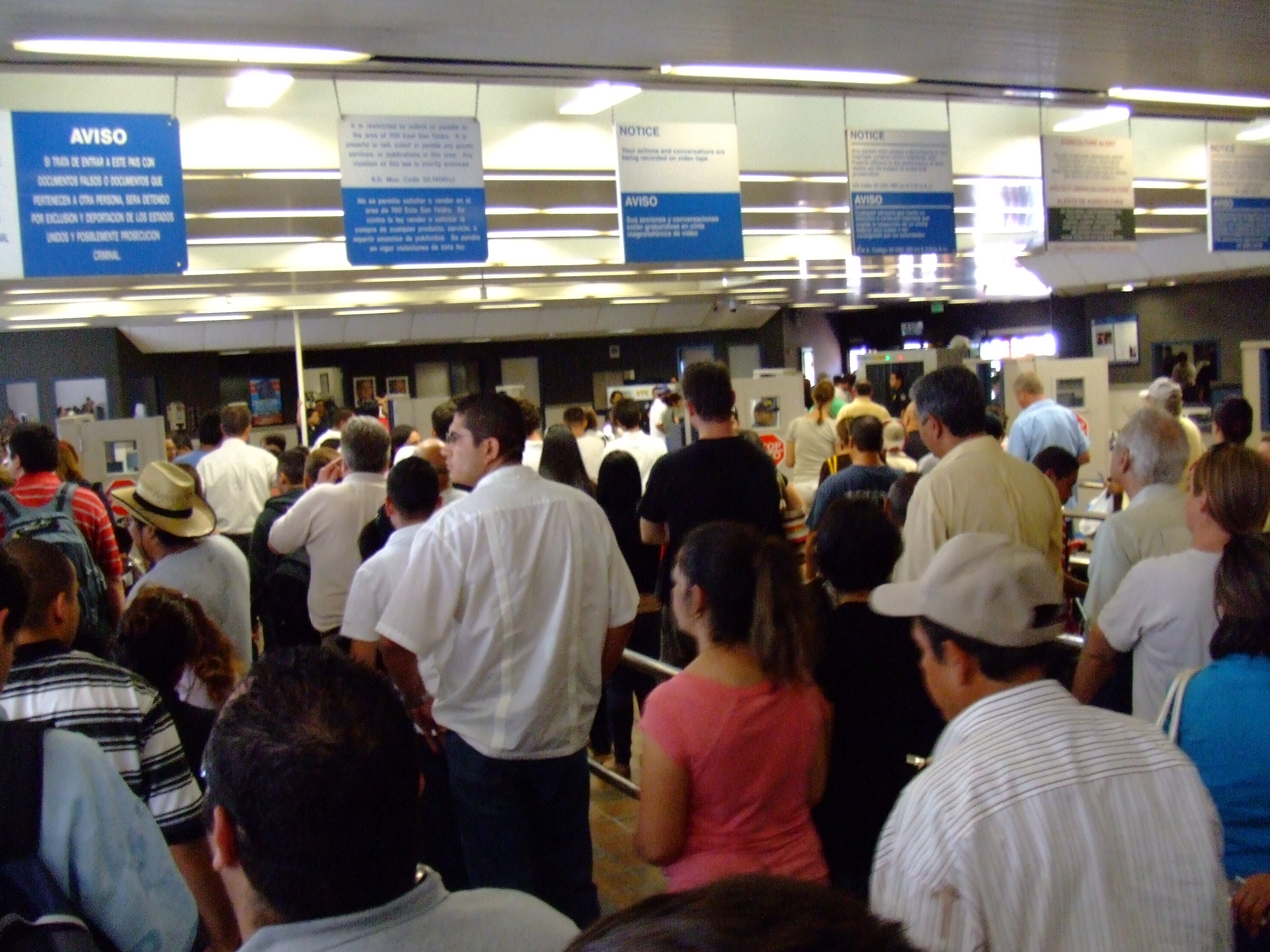 Pedestrians navigating the dedicated border crossing turnstiles and walkway at San Ysidro into Tijuana